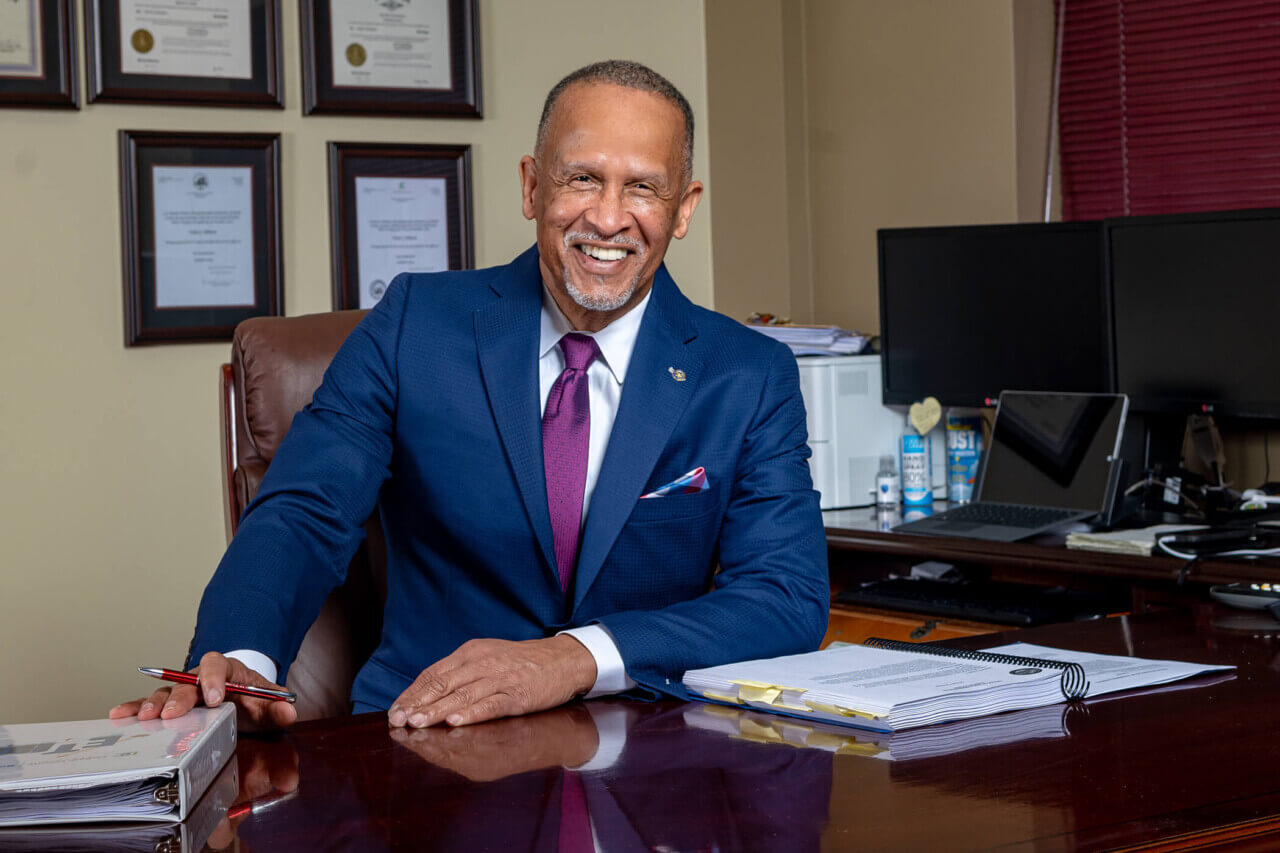 Image of DeKalb County Tax Commissioner Irvin J Johnson smiling at his desk.