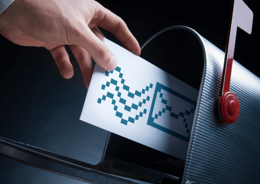 Dramatic image of hand placing mail into mailbox.