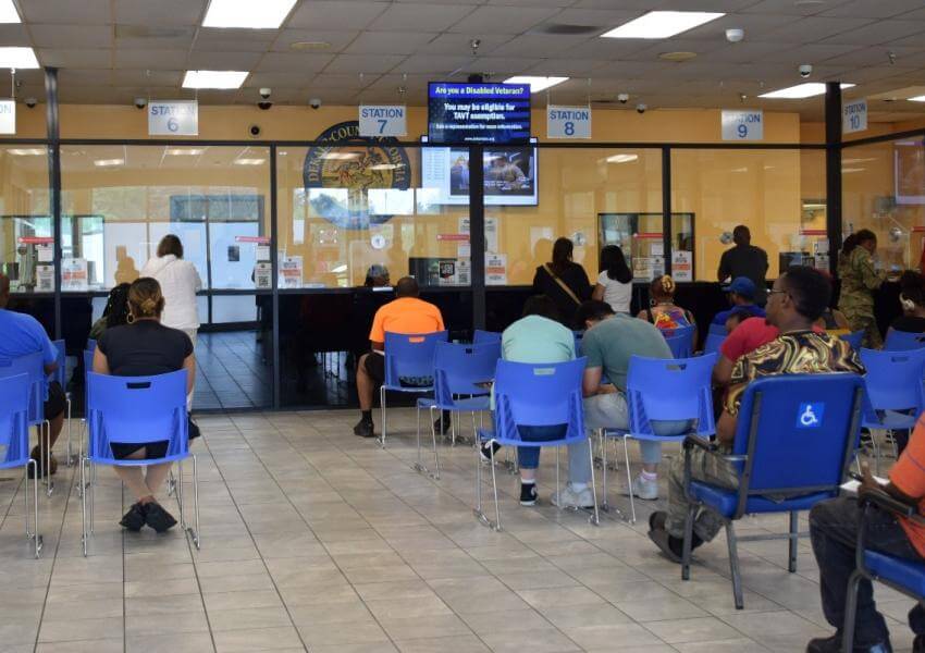 People waiting in blue chairs at the motor vehicle lobby memorial drive.